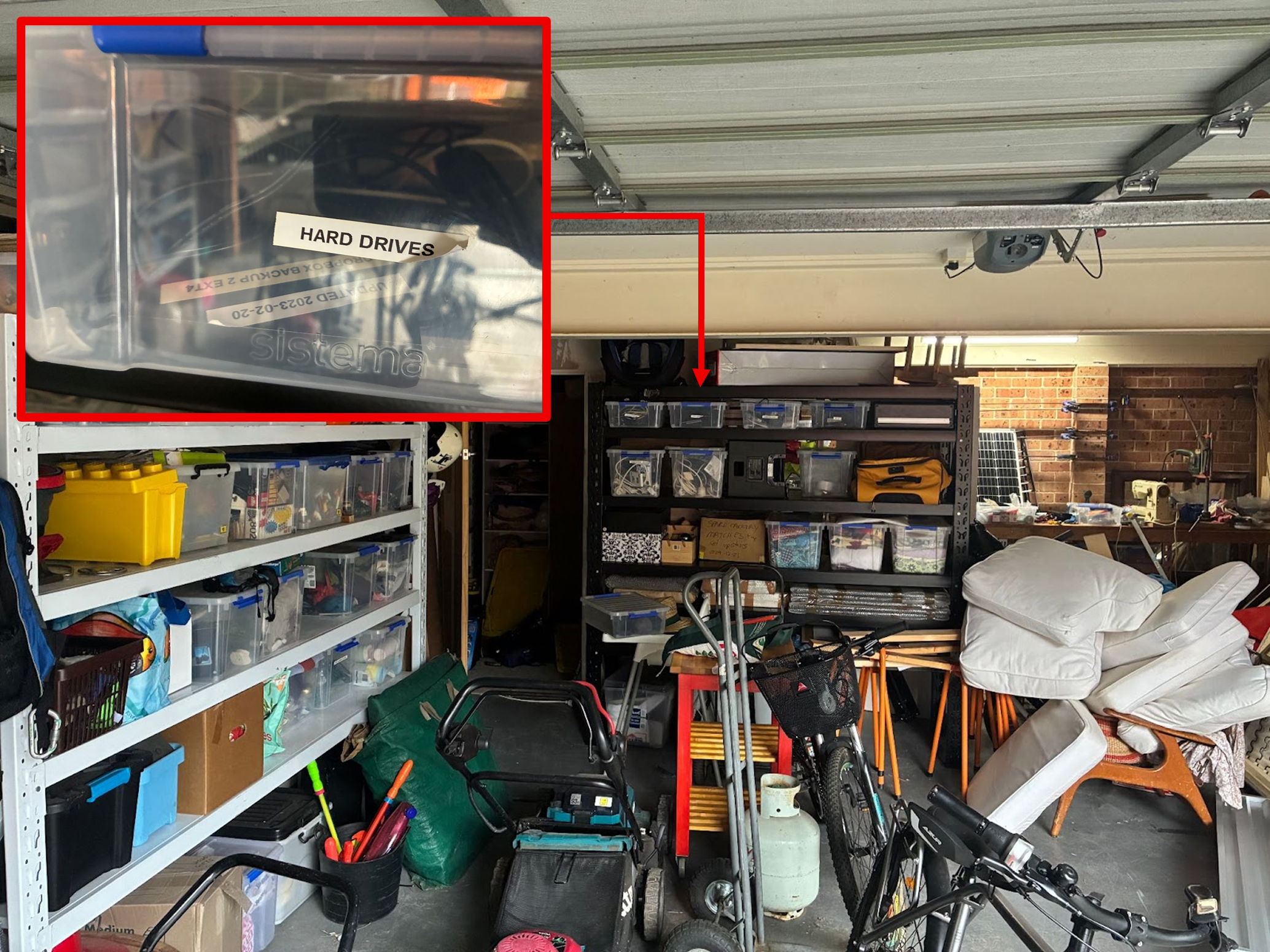 Figure 1: An unstaged photo of PT Sefton's garage, including a box labelled 'hard drives'. Piles of boxes in a garage