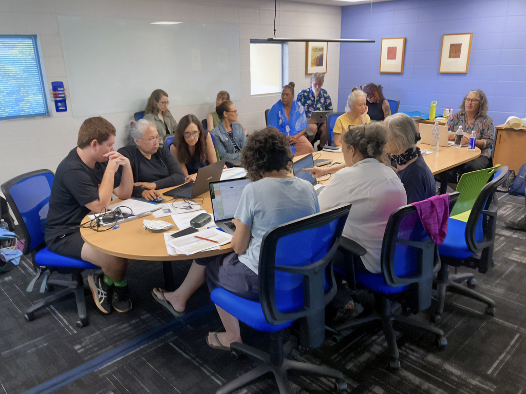 Workshop participants getting involved Photograph of workshop participants sitting in a big group around a table, getting involved in hands-on activities for metadata organisation and description.
